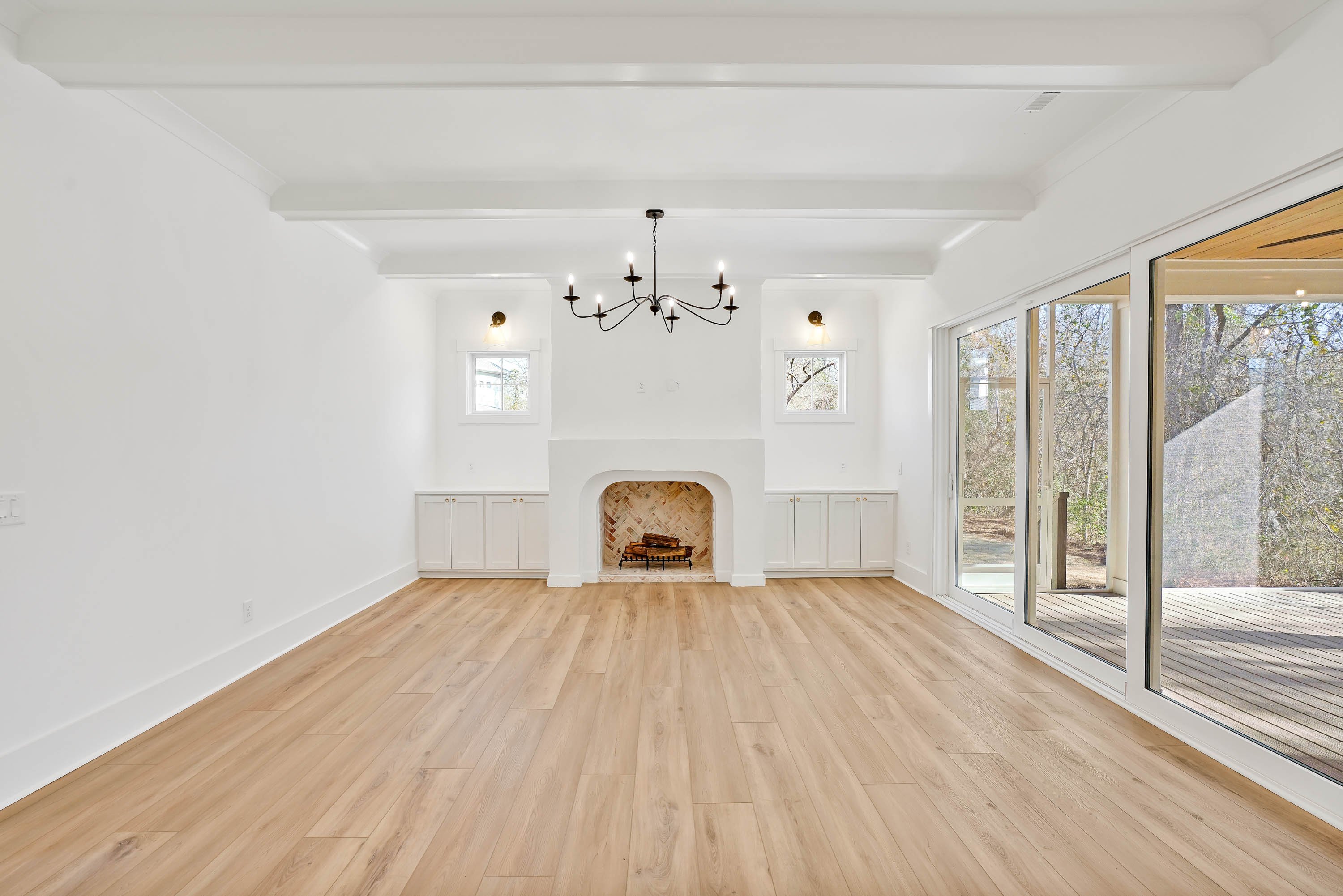 White living room, unfurnished, fireplace in the middle, hardwood floor